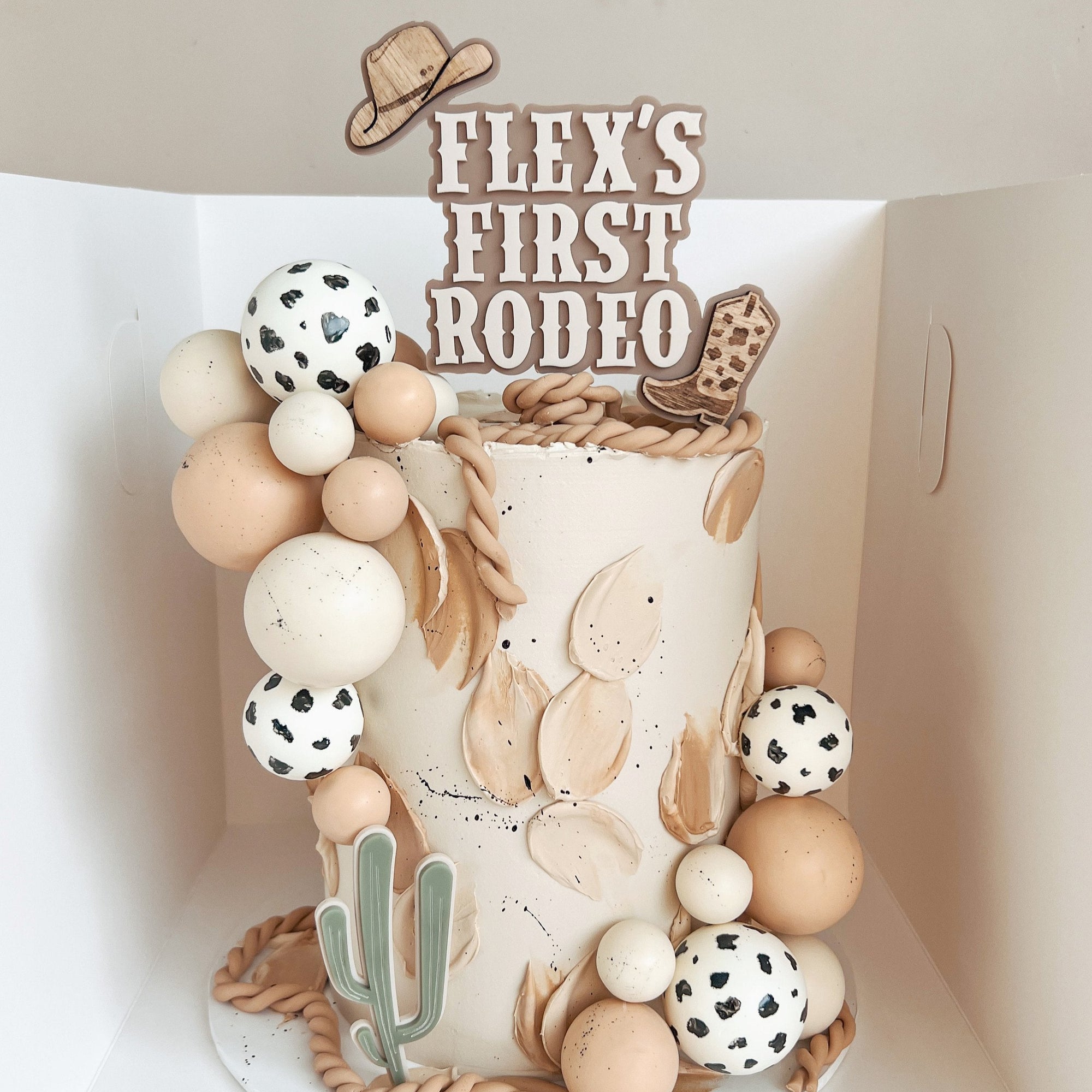 First Rodeo - Cake Topper Set-featuring a cowboy boot and a cowboy hat sitting on top of a cake